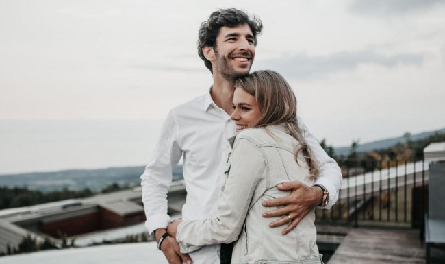a man and woman hugging on rooftop terrace