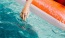 woman dangles her hand in the pool as she floats in an inflatable vessel